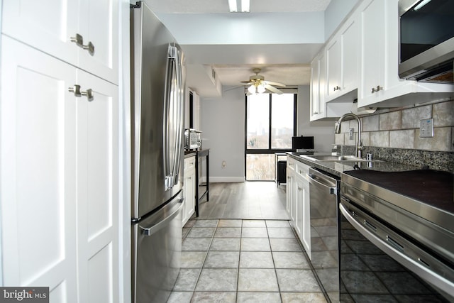 kitchen with white cabinetry, sink, decorative backsplash, ceiling fan, and stainless steel appliances