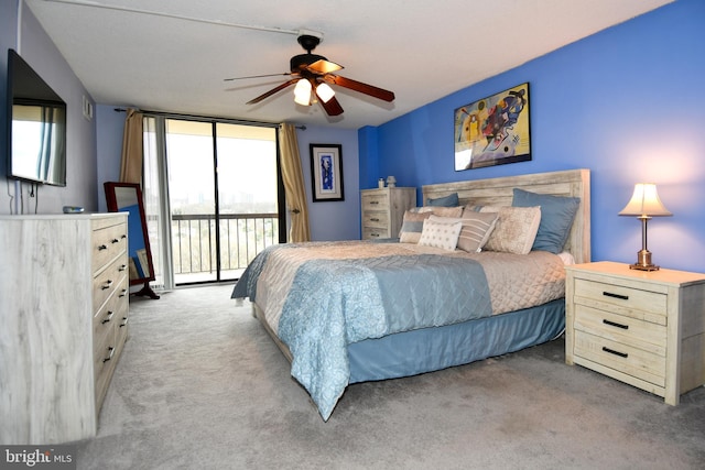 bedroom with ceiling fan, light colored carpet, access to exterior, and a wall of windows