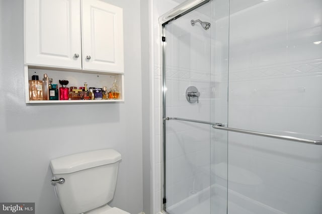 bathroom with a shower with door and toilet