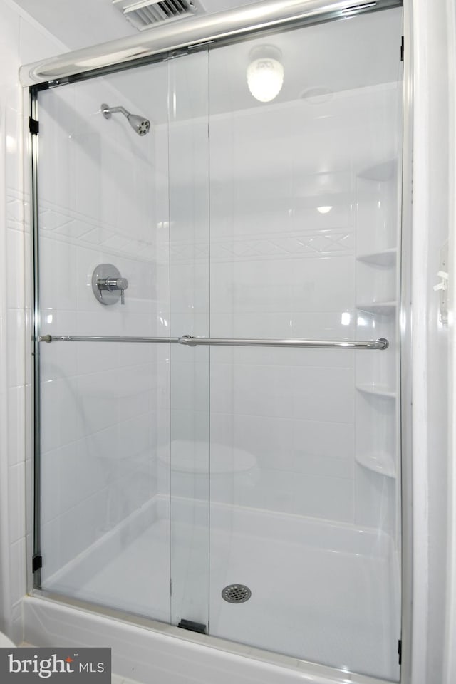 bathroom featuring a shower with shower door