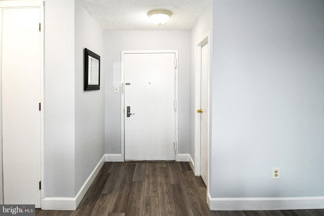 entryway with dark wood-type flooring and a textured ceiling