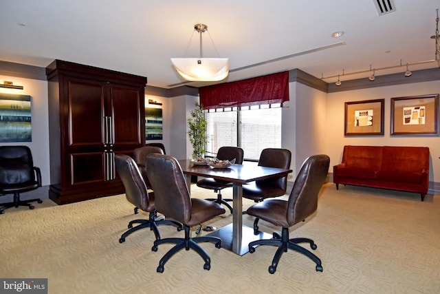 carpeted dining area featuring track lighting