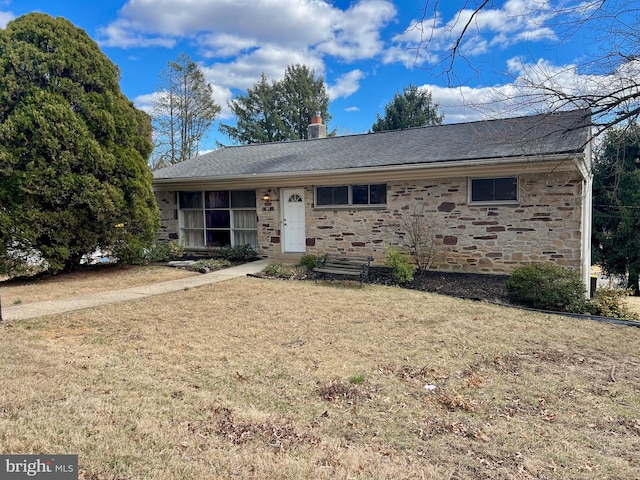 ranch-style house featuring a front yard, stone siding, roof with shingles, and a chimney