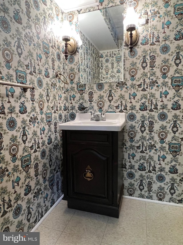 bathroom featuring wallpapered walls, vanity, baseboards, and tile patterned floors