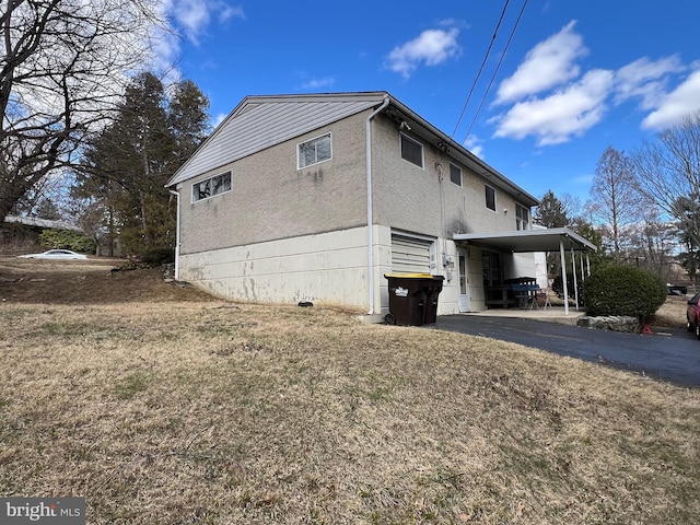 view of property exterior with a yard, driveway, and an attached carport