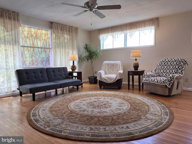 sitting room featuring a ceiling fan, baseboards, and wood finished floors