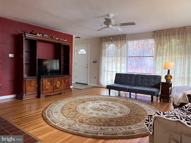 living area featuring ceiling fan, wood finished floors, and baseboards