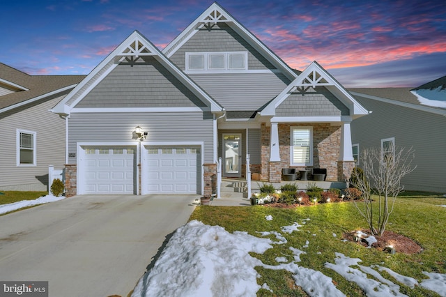 craftsman house with a garage, a yard, and covered porch