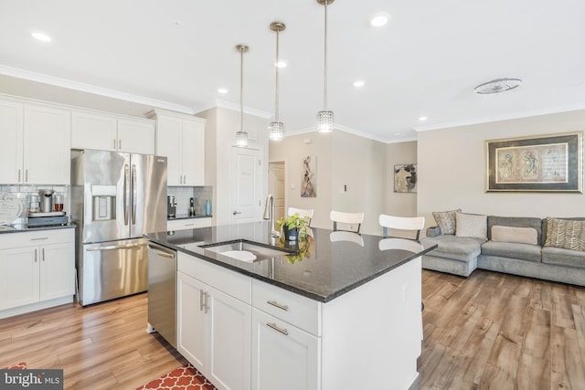 kitchen featuring a kitchen island with sink, appliances with stainless steel finishes, sink, and white cabinets