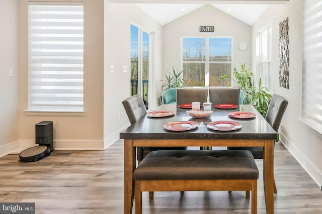 dining space featuring vaulted ceiling and wood-type flooring