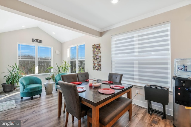 dining area featuring hardwood / wood-style flooring and vaulted ceiling