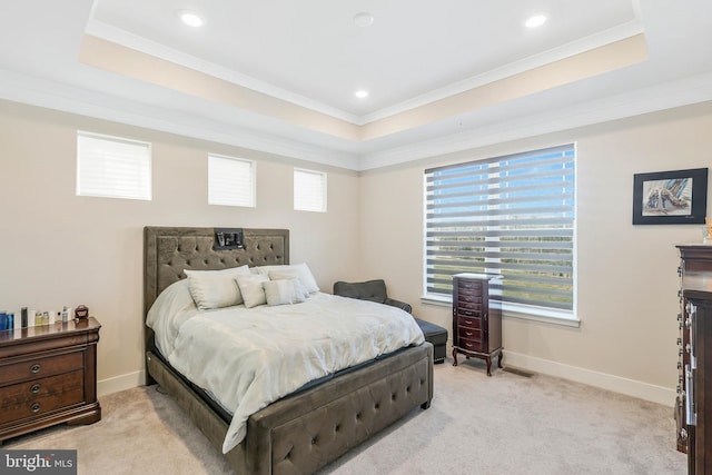 bedroom with multiple windows, light colored carpet, and a raised ceiling