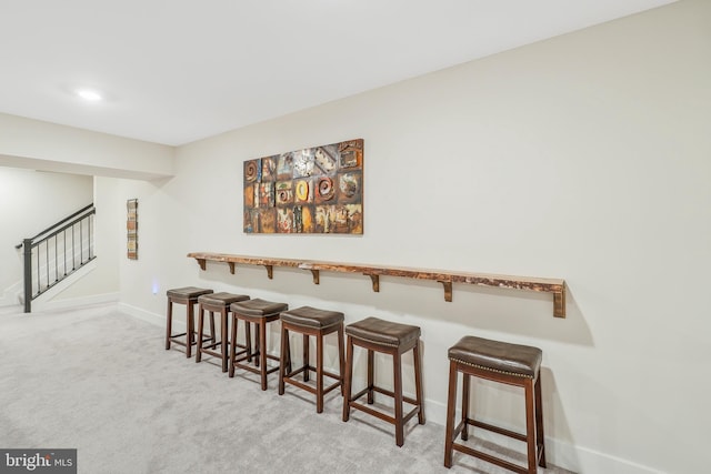 carpeted dining area featuring bar