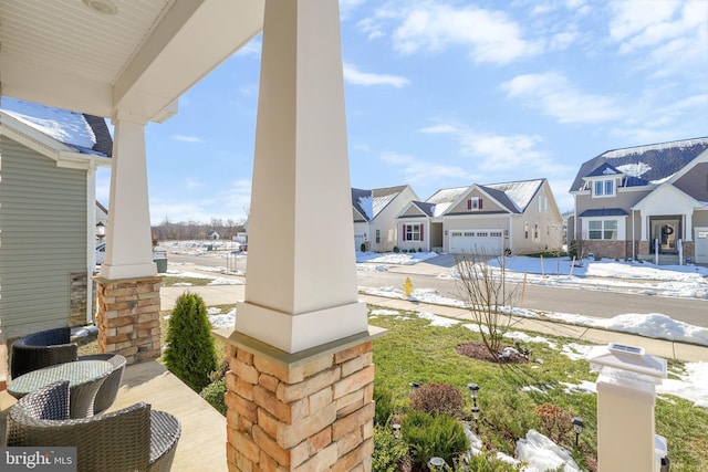 view of patio / terrace featuring a porch and a garage