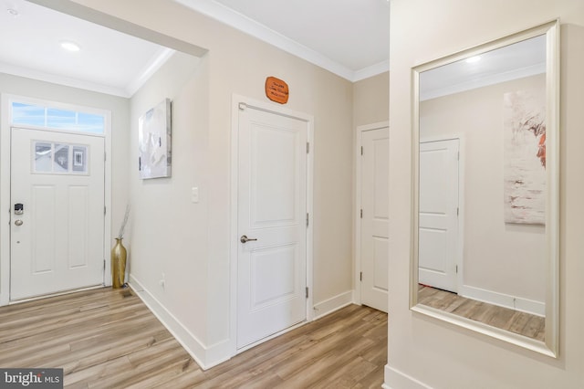 foyer featuring ornamental molding and light hardwood / wood-style flooring