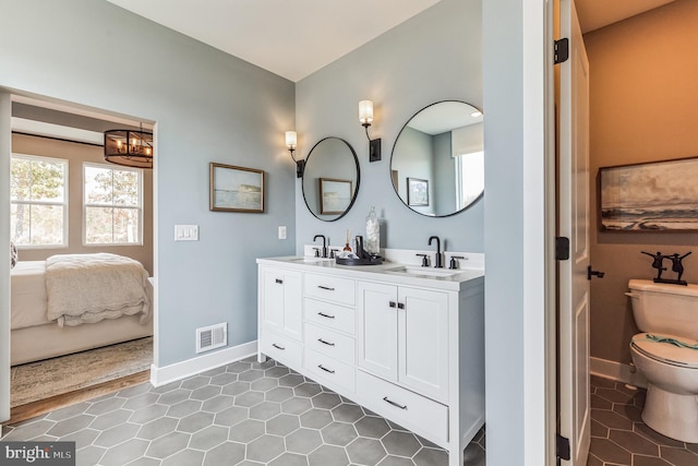 bathroom with vanity, tile patterned flooring, toilet, and an inviting chandelier