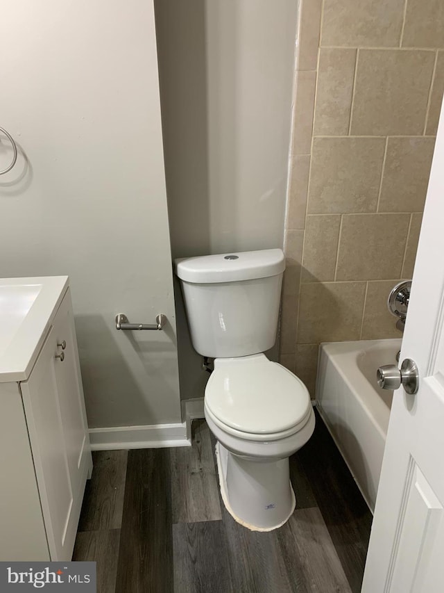 full bathroom with vanity, tiled shower / bath combo, wood-type flooring, and toilet