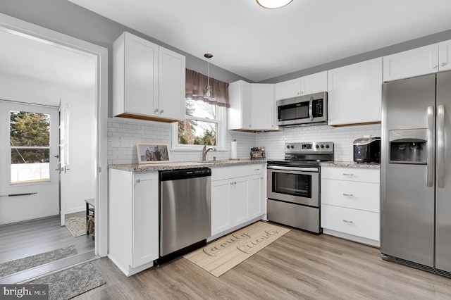 kitchen with white cabinetry, sink, light hardwood / wood-style flooring, and appliances with stainless steel finishes