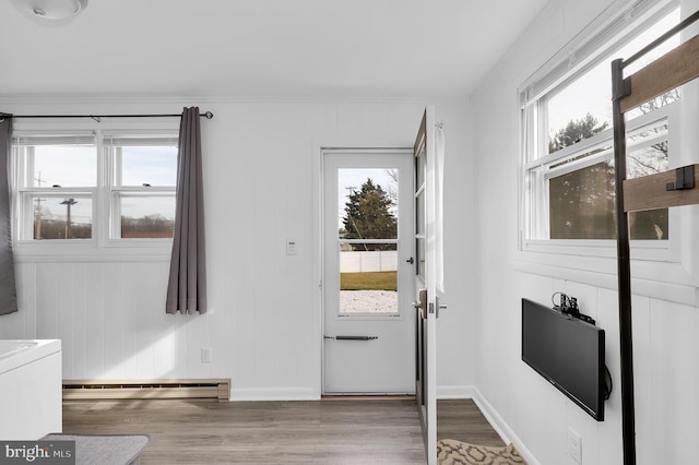 doorway featuring a baseboard radiator, a healthy amount of sunlight, and light hardwood / wood-style floors