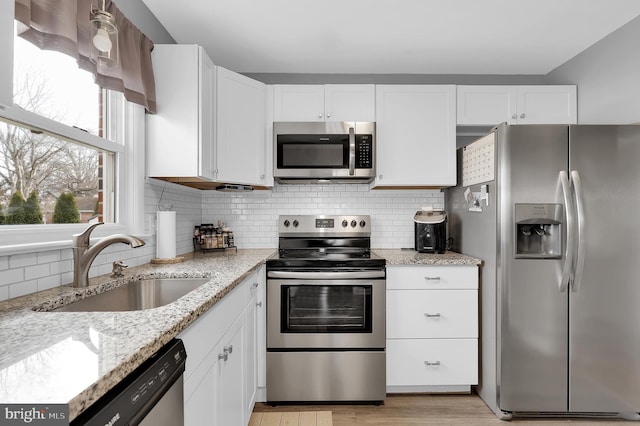 kitchen featuring appliances with stainless steel finishes, sink, and white cabinets