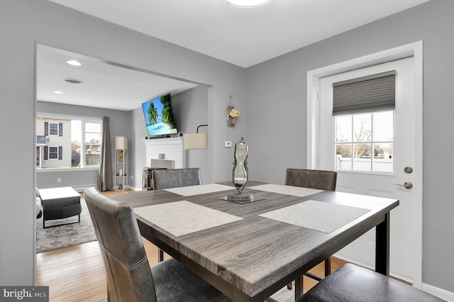 dining room featuring a fireplace and light wood-type flooring