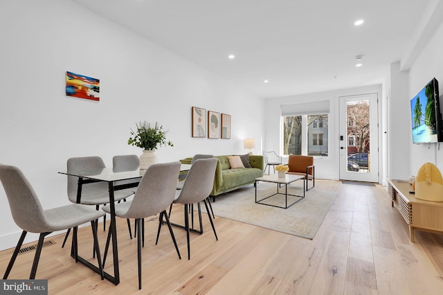 dining space with light wood-style floors, recessed lighting, and visible vents