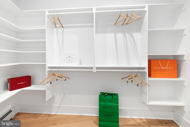 walk in closet featuring hardwood / wood-style flooring and a baseboard radiator