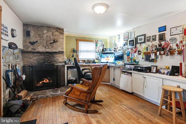 kitchen with white cabinetry, a fireplace, and light hardwood / wood-style floors