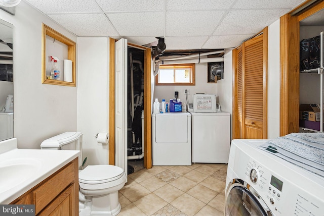 laundry room featuring light tile patterned flooring, sink, and washing machine and dryer