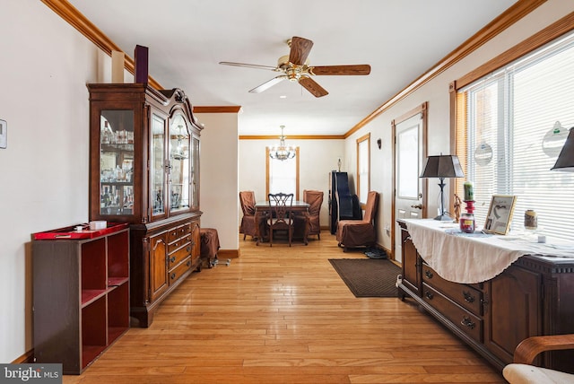 living area with crown molding, ceiling fan with notable chandelier, and light hardwood / wood-style floors