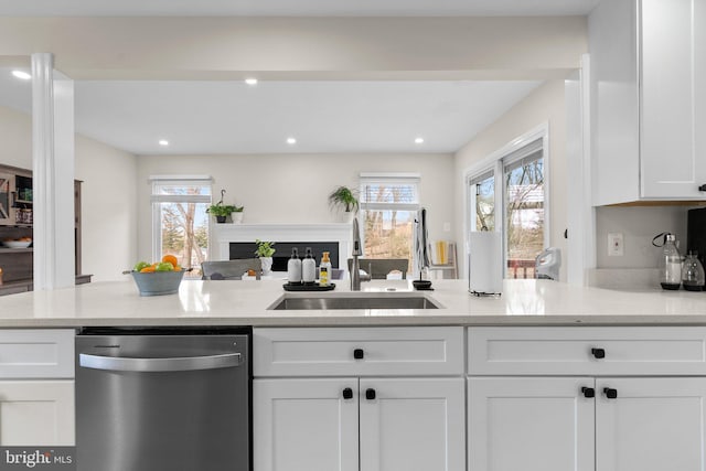 kitchen with sink, dishwasher, light stone counters, and white cabinets