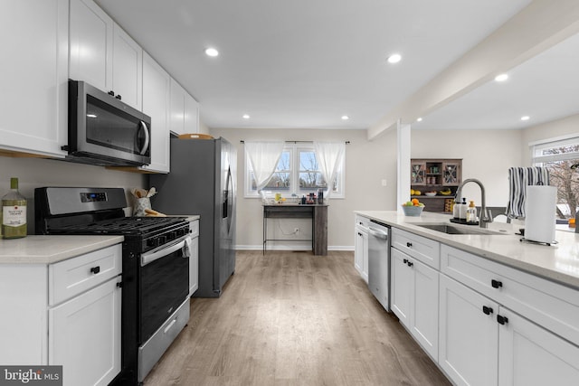 kitchen with white cabinetry, stainless steel appliances, and sink