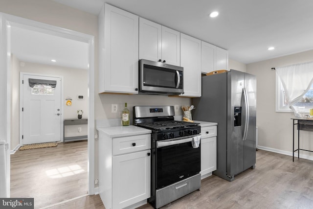 kitchen featuring appliances with stainless steel finishes, light wood-type flooring, and white cabinets