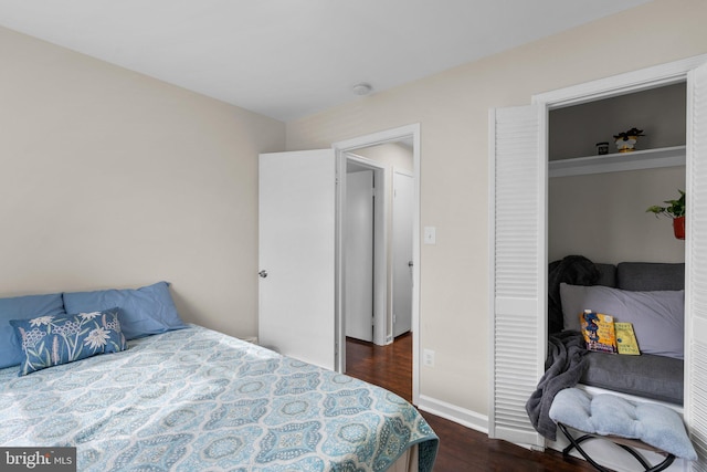 bedroom with dark wood-type flooring and a closet