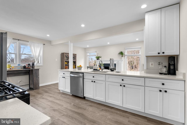 kitchen with black range with gas stovetop, stainless steel dishwasher, light hardwood / wood-style floors, sink, and white cabinetry