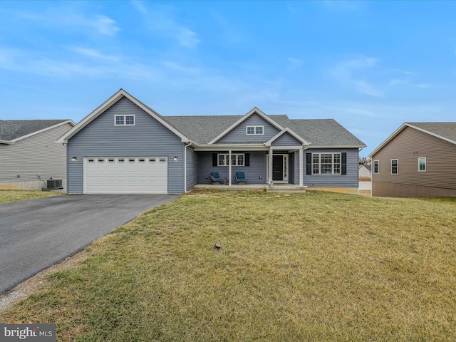 view of front of property with a garage, a porch, cooling unit, and a front yard