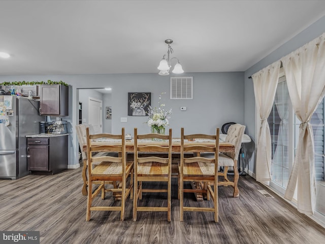 dining room featuring hardwood / wood-style flooring and a chandelier