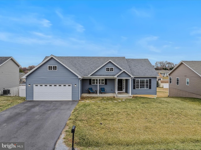 view of front of house with a garage, a front yard, central AC unit, and covered porch