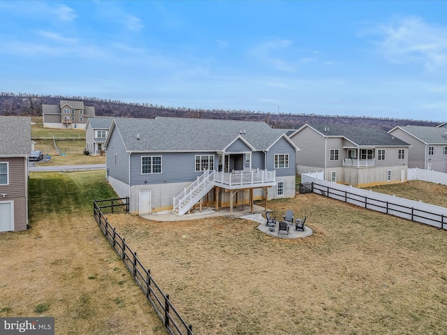 view of front of property with a wooden deck, a front lawn, and a patio area