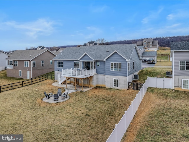 view of front of property with a wooden deck, a fire pit, a front yard, and a patio