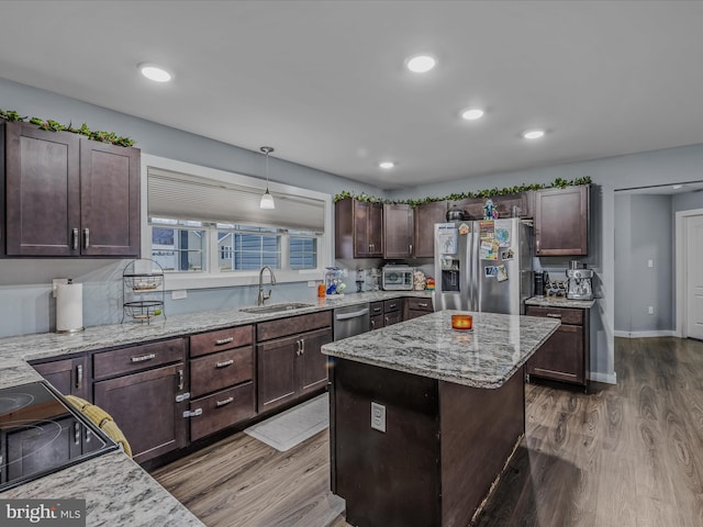 kitchen featuring sink, dark brown cabinets, a kitchen island, pendant lighting, and stainless steel appliances