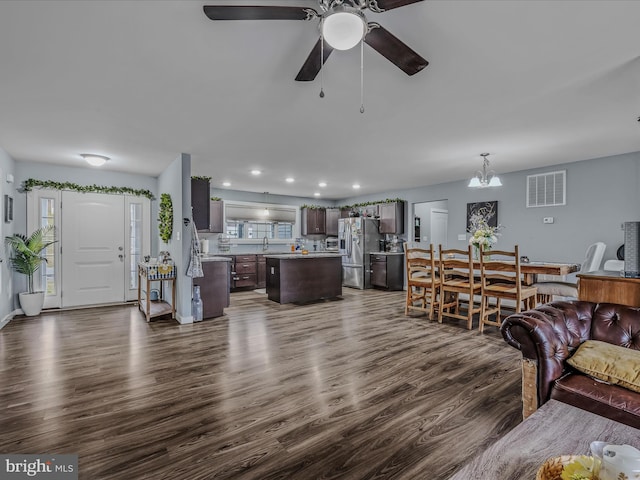 living room featuring dark wood-type flooring, sink, and ceiling fan