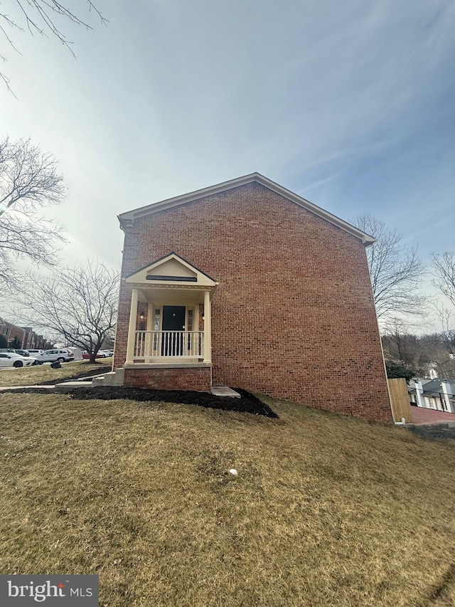 view of property exterior with a yard and a porch