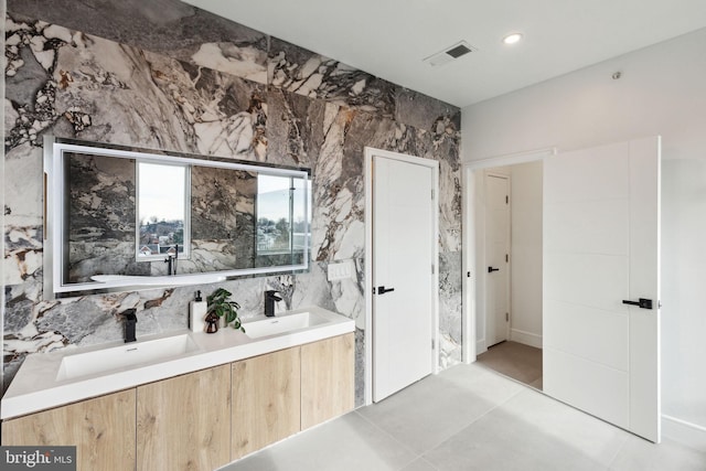 bathroom with decorative backsplash, vanity, tile patterned flooring, and tile walls