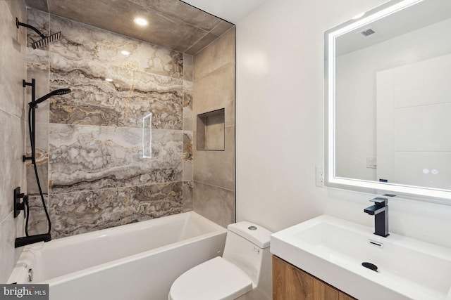 full bathroom with vanity, tiled shower / bath, and toilet