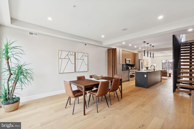 dining room featuring sink and light hardwood / wood-style flooring