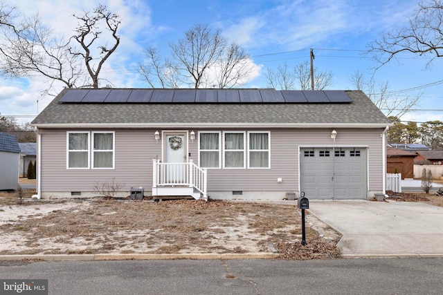 ranch-style house featuring a garage and solar panels