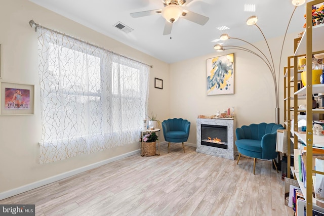 living area with light hardwood / wood-style floors and ceiling fan