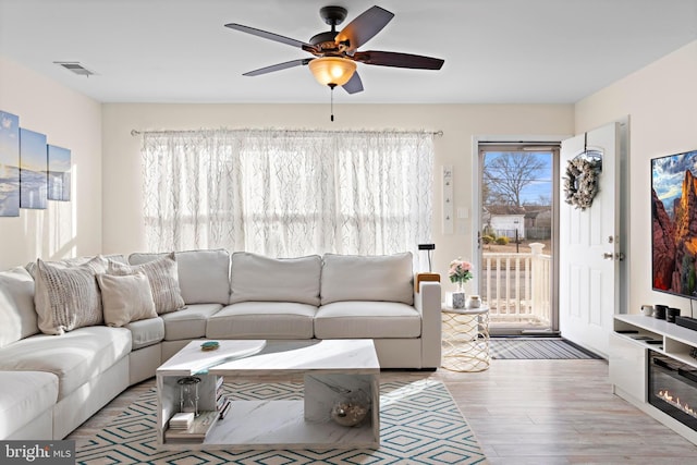 living room with ceiling fan and light hardwood / wood-style flooring