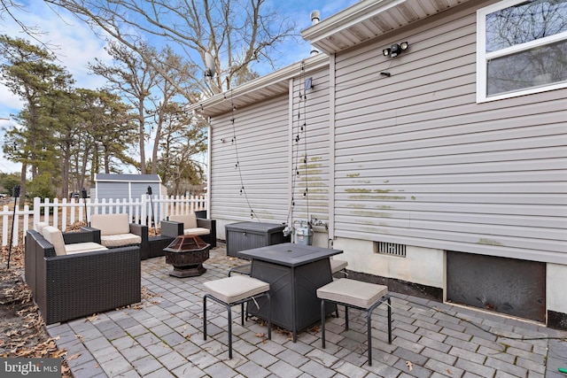 view of patio with a shed and an outdoor living space with a fire pit